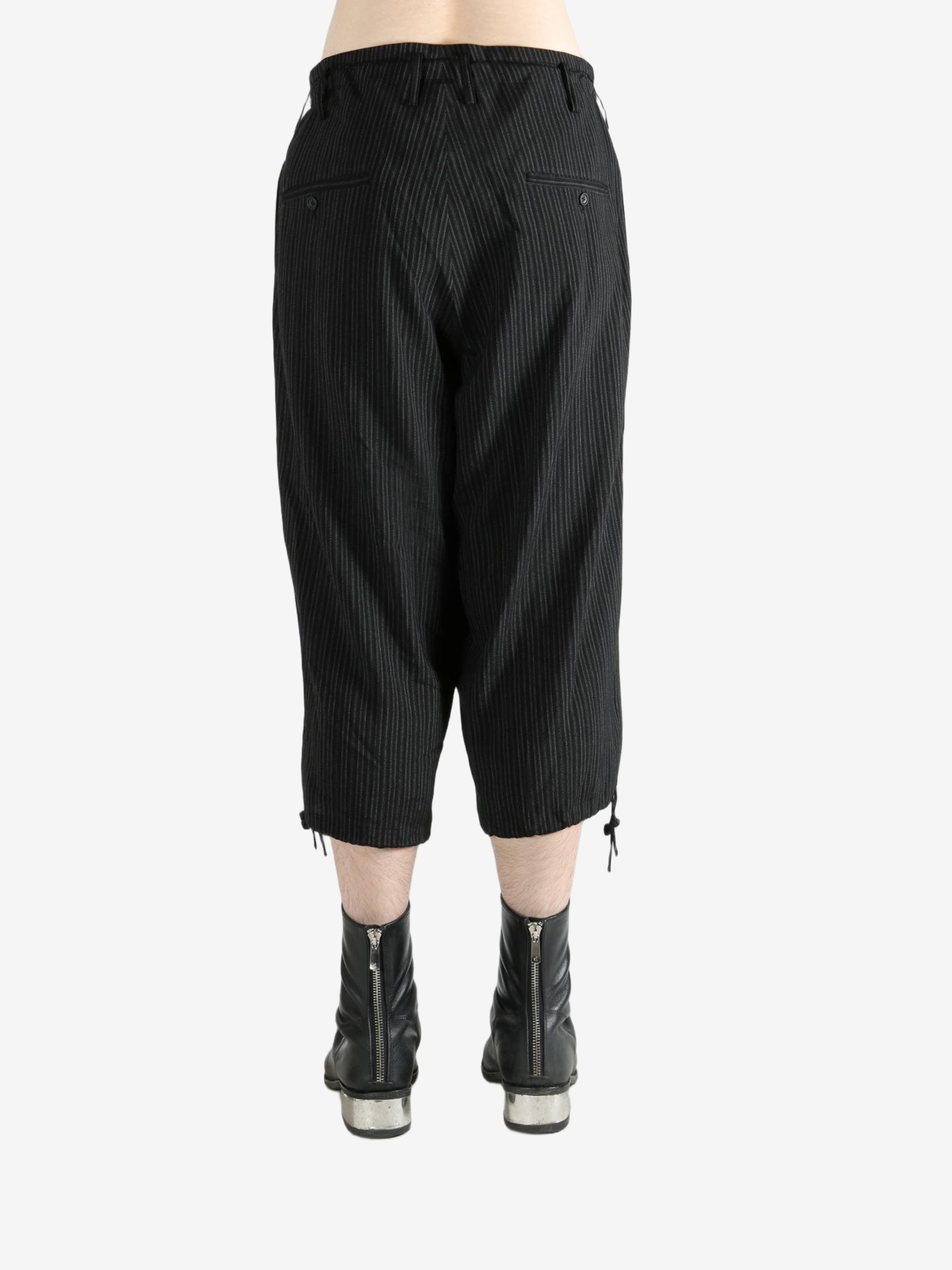 Black pants worn by a person, showing the pants's fit