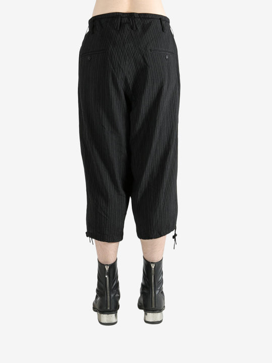 Black pants worn by a person, showing the pants's fit