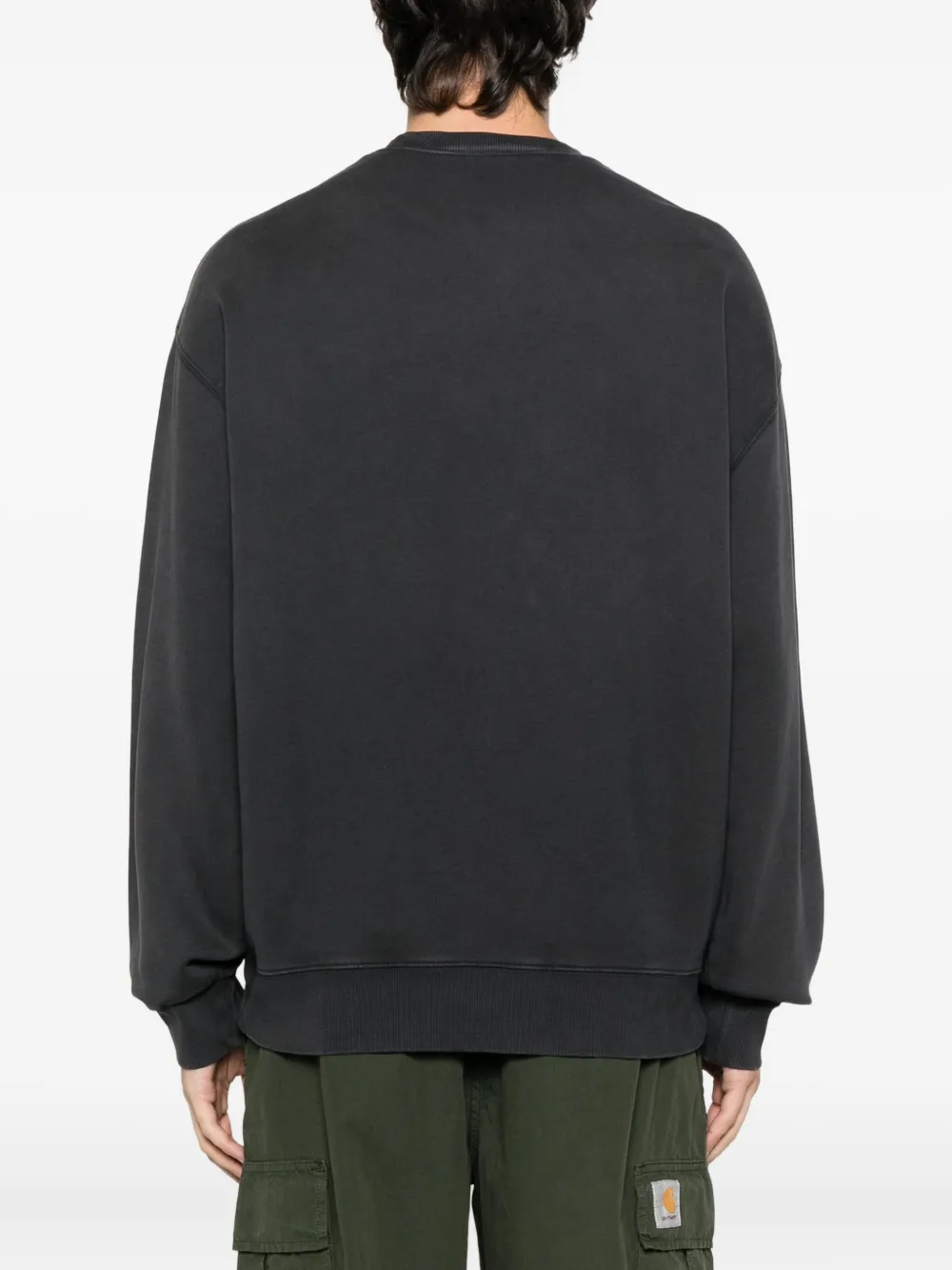 Black sweat worn by a person, showing the sweat's fit