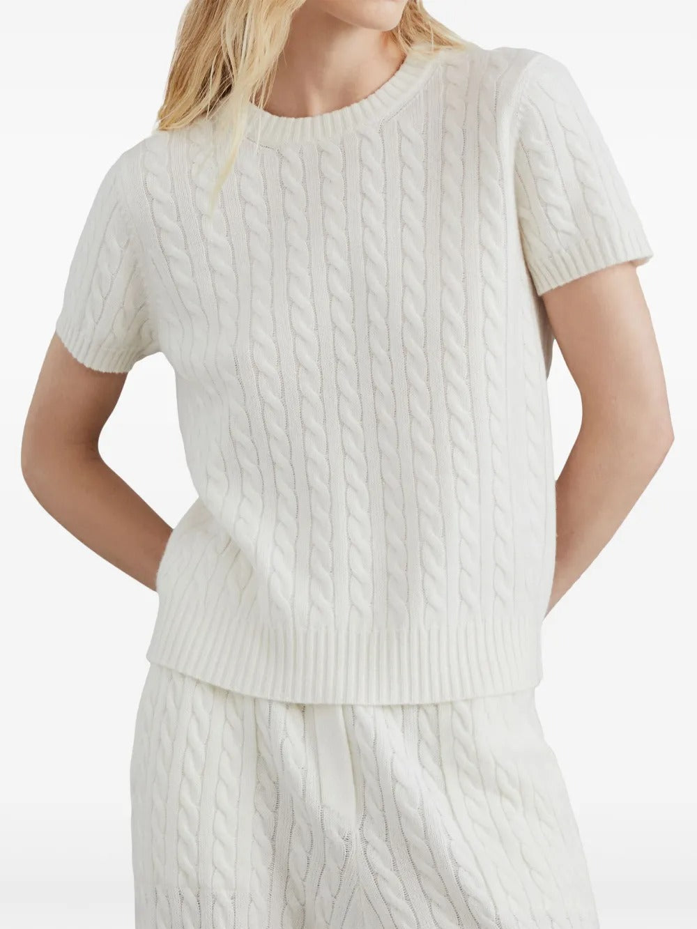 White knitwear worn by a person, showing the knitwear's fit