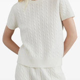 White knitwear worn by a person, showing the knitwear's fit
