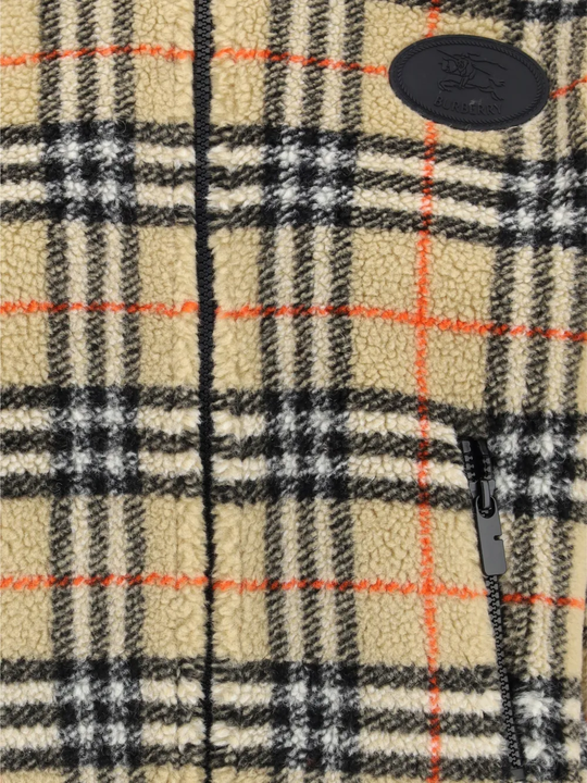 Close up of tan jackets, showing texture of the wool and polyester fabric
