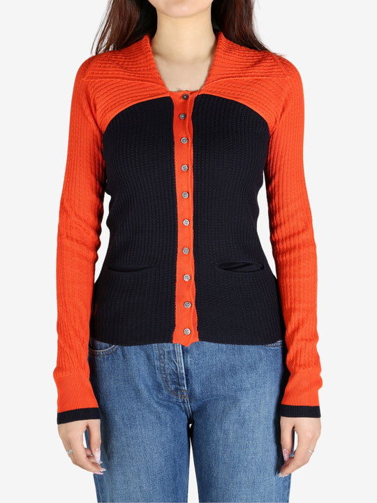 Orange top worn by a person, showing the top’s fit