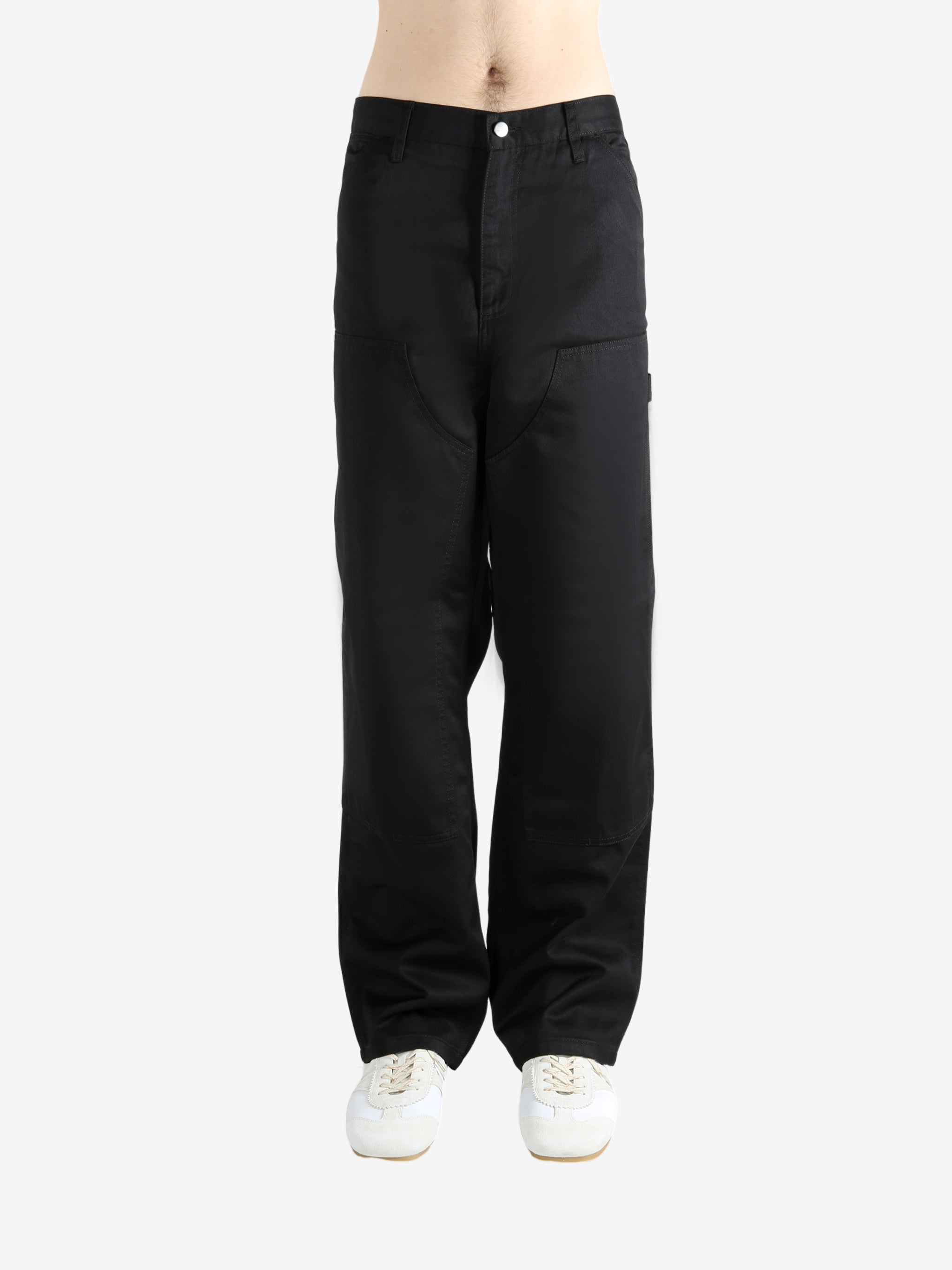 Black pants worn by a person, showing the pants' fit