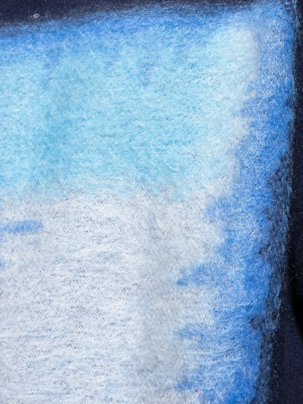 Close up of the blue sweater, showing texture of the wool fabric