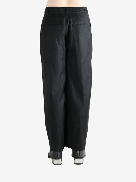 Black pants worn by a person, showing the pants fit