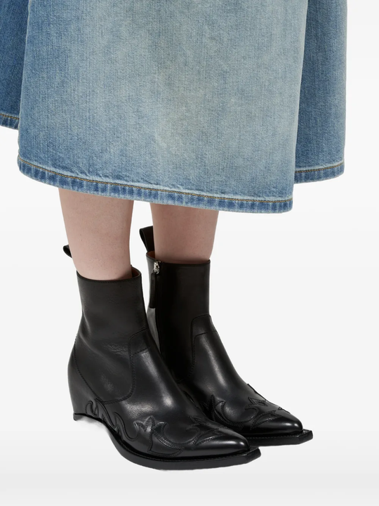 Black boot worn by a person, showing the boot 's fit
