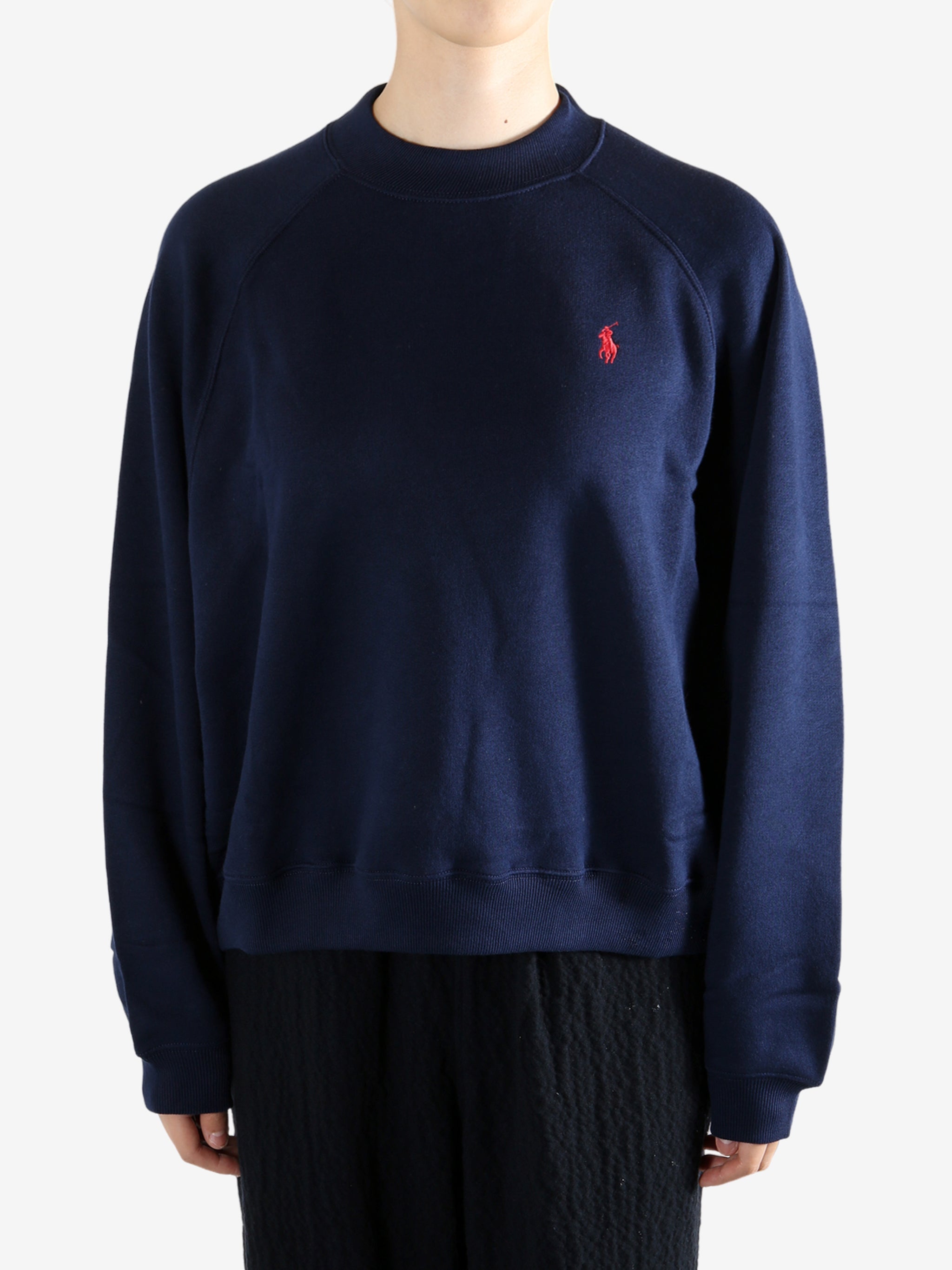 Navy knitwear worn by a person, showing the knitwear fit