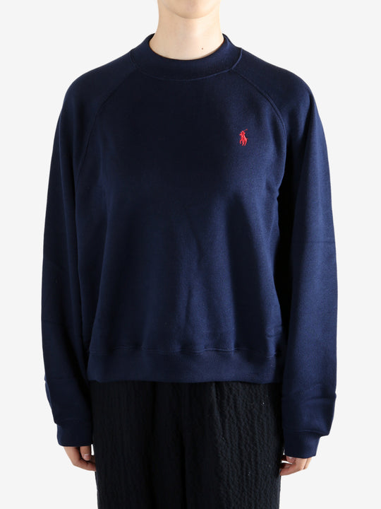 Navy knitwear worn by a person, showing the knitwear fit