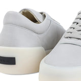 Close up of grey sneakers, showing texture of the leather fabric