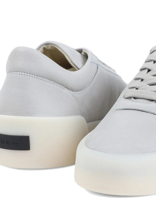 Close up of grey sneakers, showing texture of the leather fabric