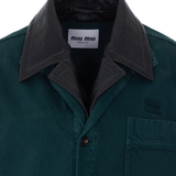 Close up of green coats, showing texture of the gabardine fabric