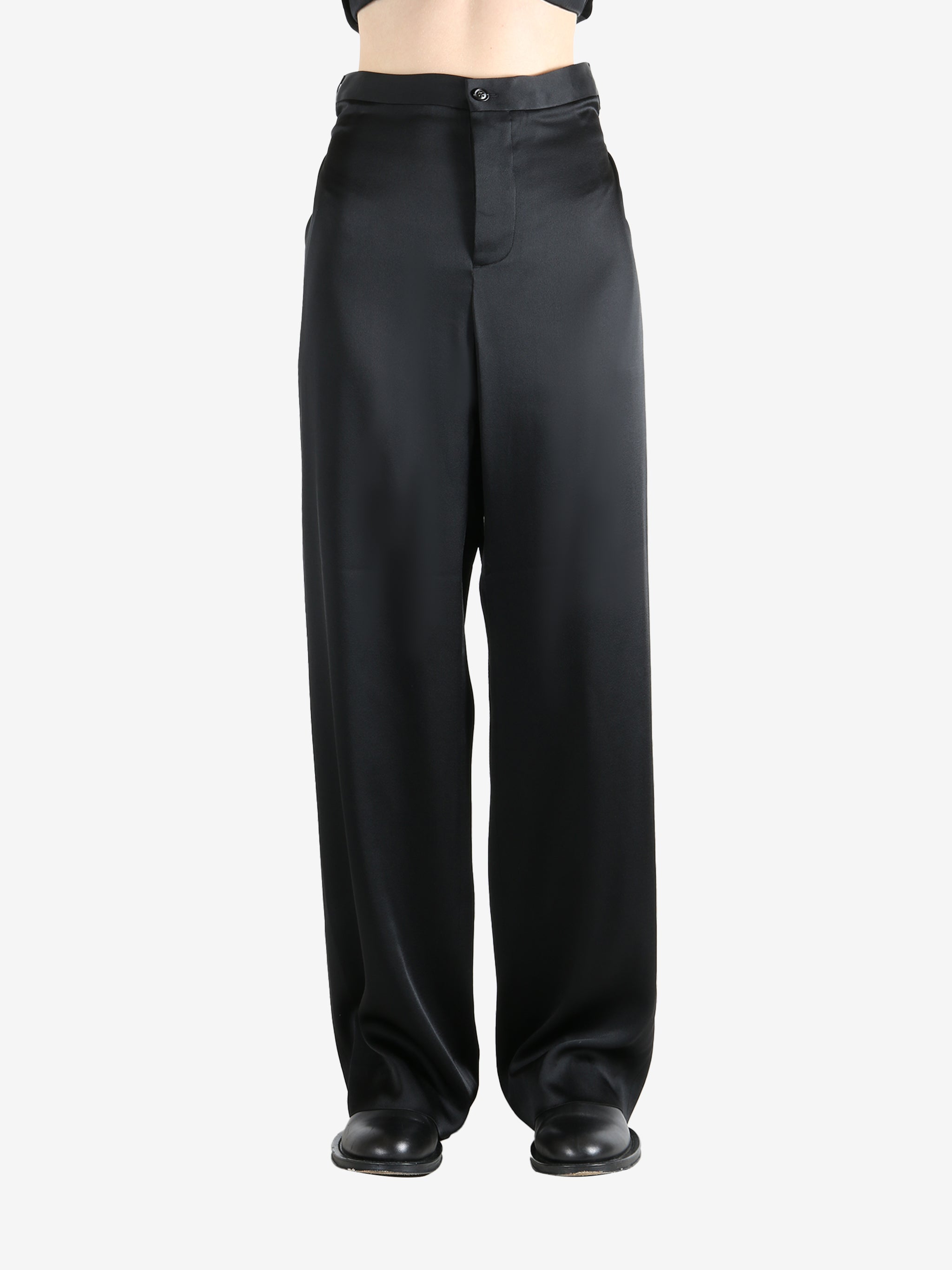 Black pants worn by a person, showing the pants' fit