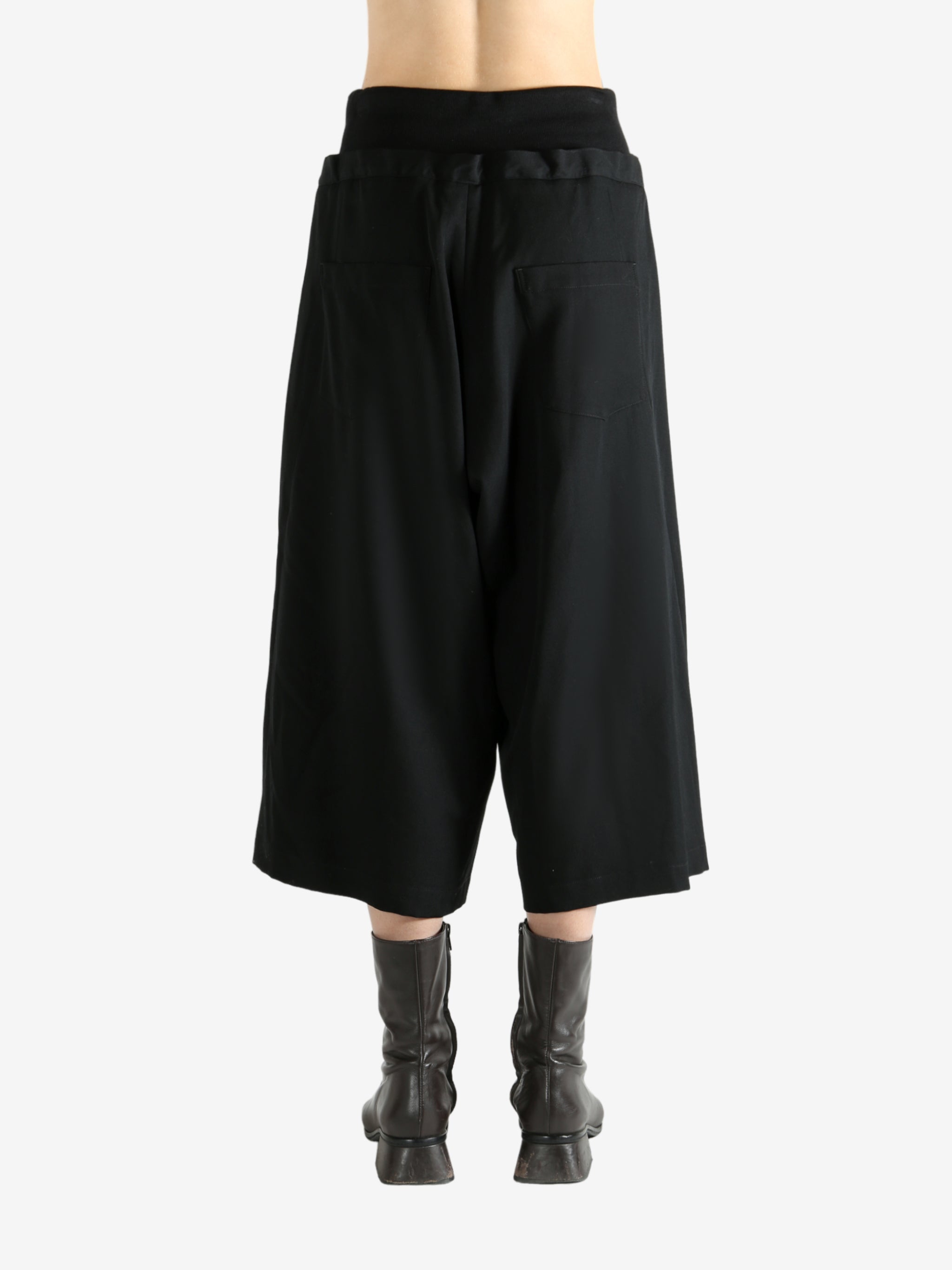 Black pants worn by a person, showing the pants fit