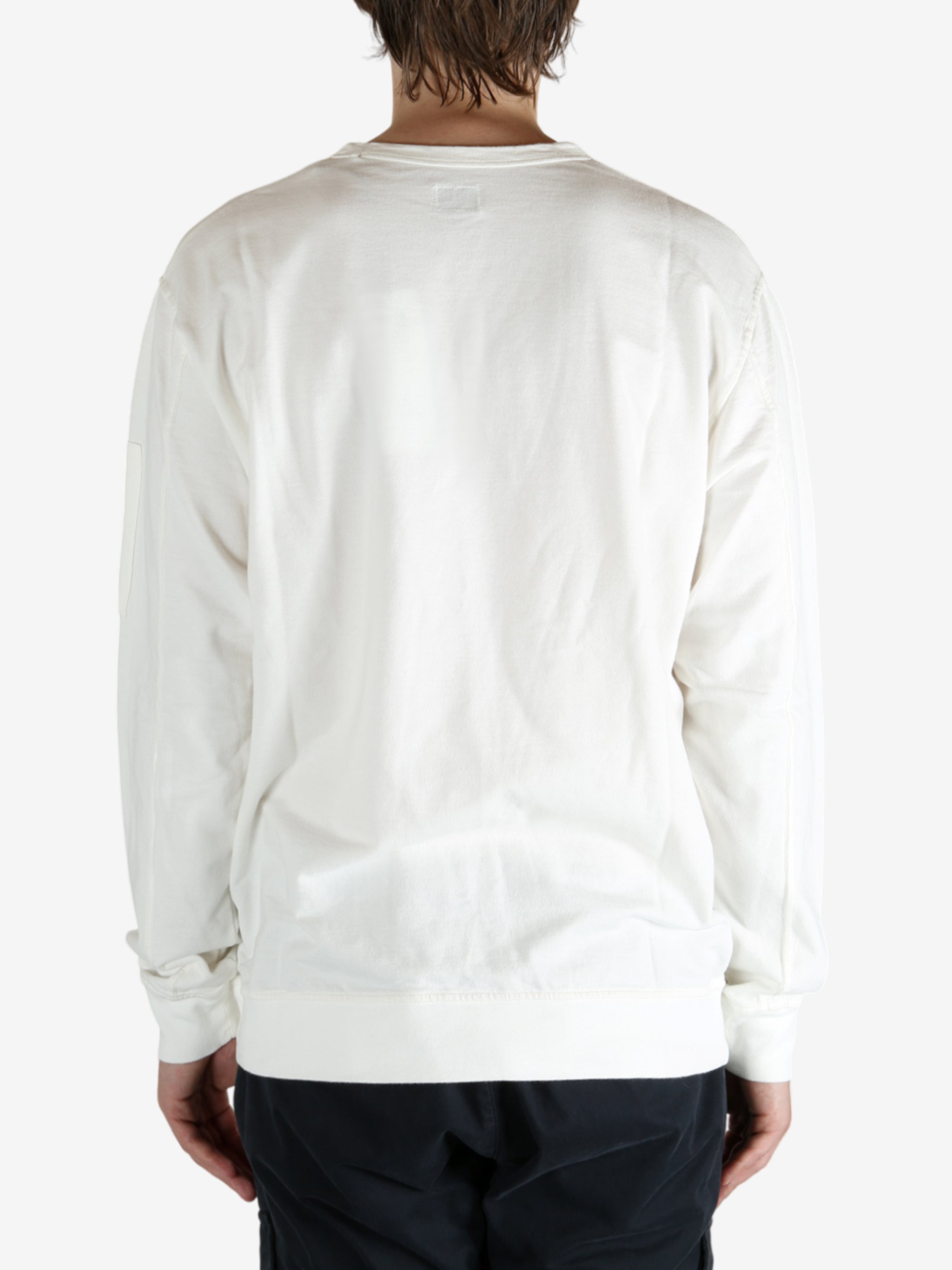 White crewneck worn by a person, showing the crewneck fit