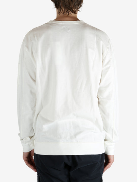 White crewneck worn by a person, showing the crewneck fit