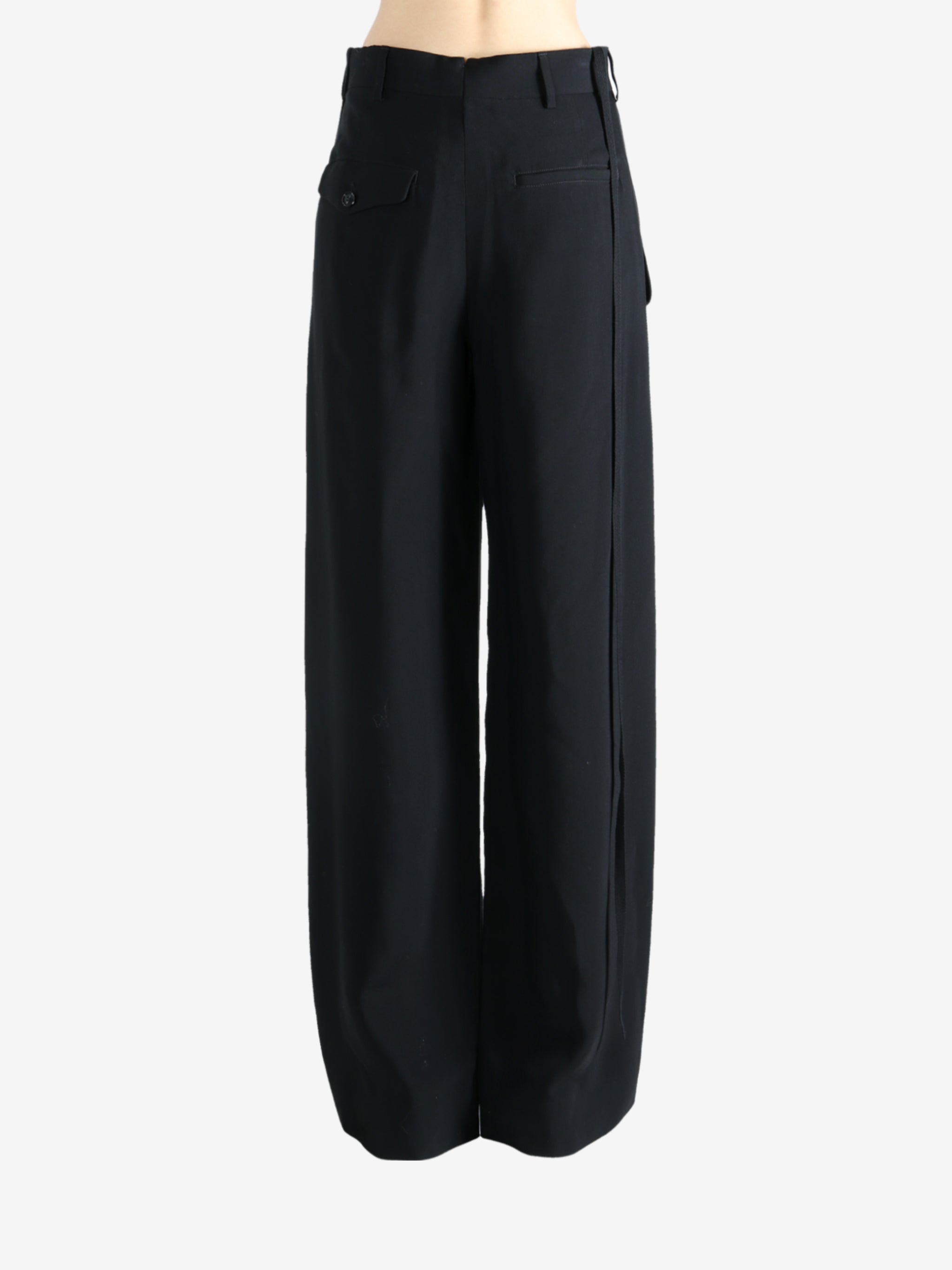 Black pants worn by a person, showing the pants' fit