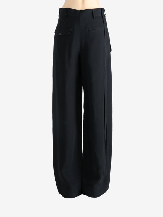 Black pants worn by a person, showing the pants' fit