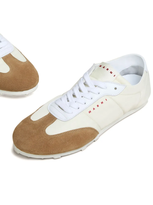 Close up of the white sneakers, showing texture of the suede and sheepskin fabric