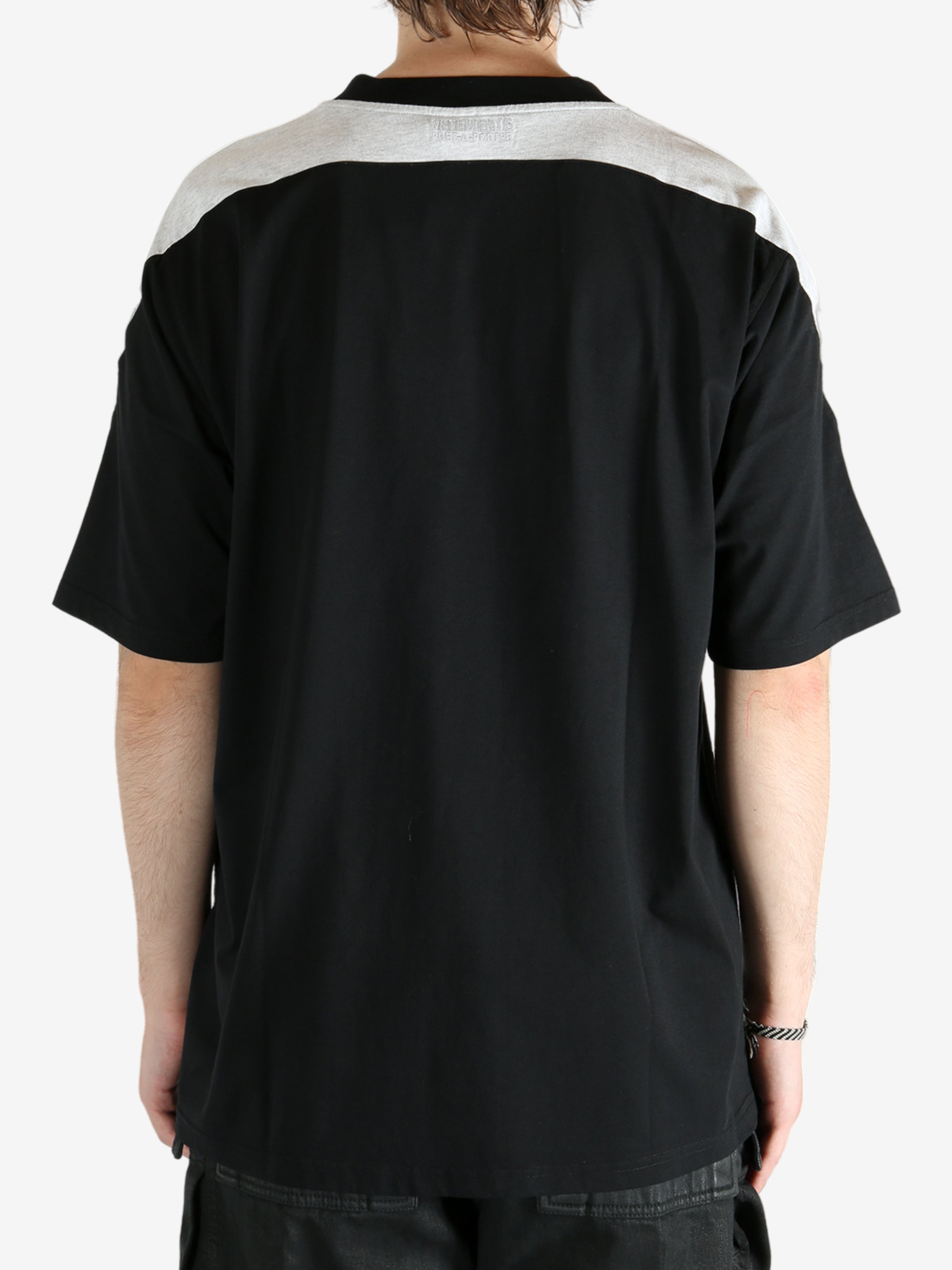 Black t-shirt worn by a person, showing the shirt's fit