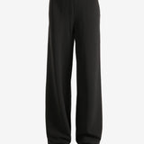 Black pants worn by a person,showing the pants' fit