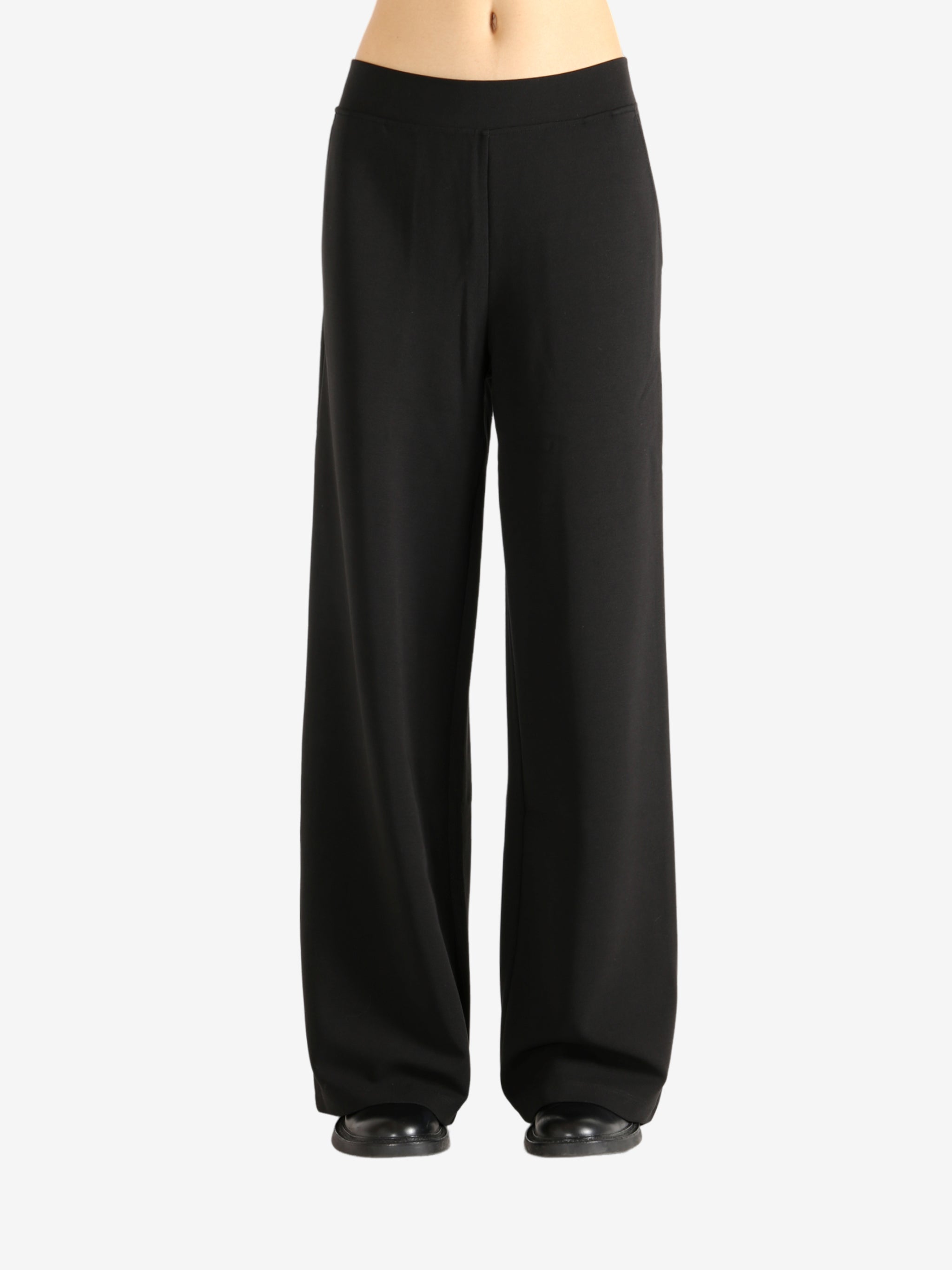 Black pants worn by a person,showing the pants' fit