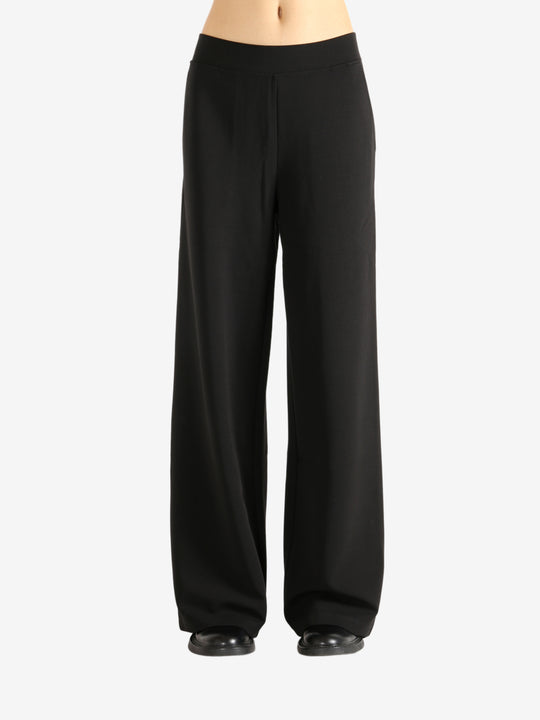 Black pants worn by a person,showing the pants' fit