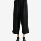 Black pants worn by a person, showing the pants fit