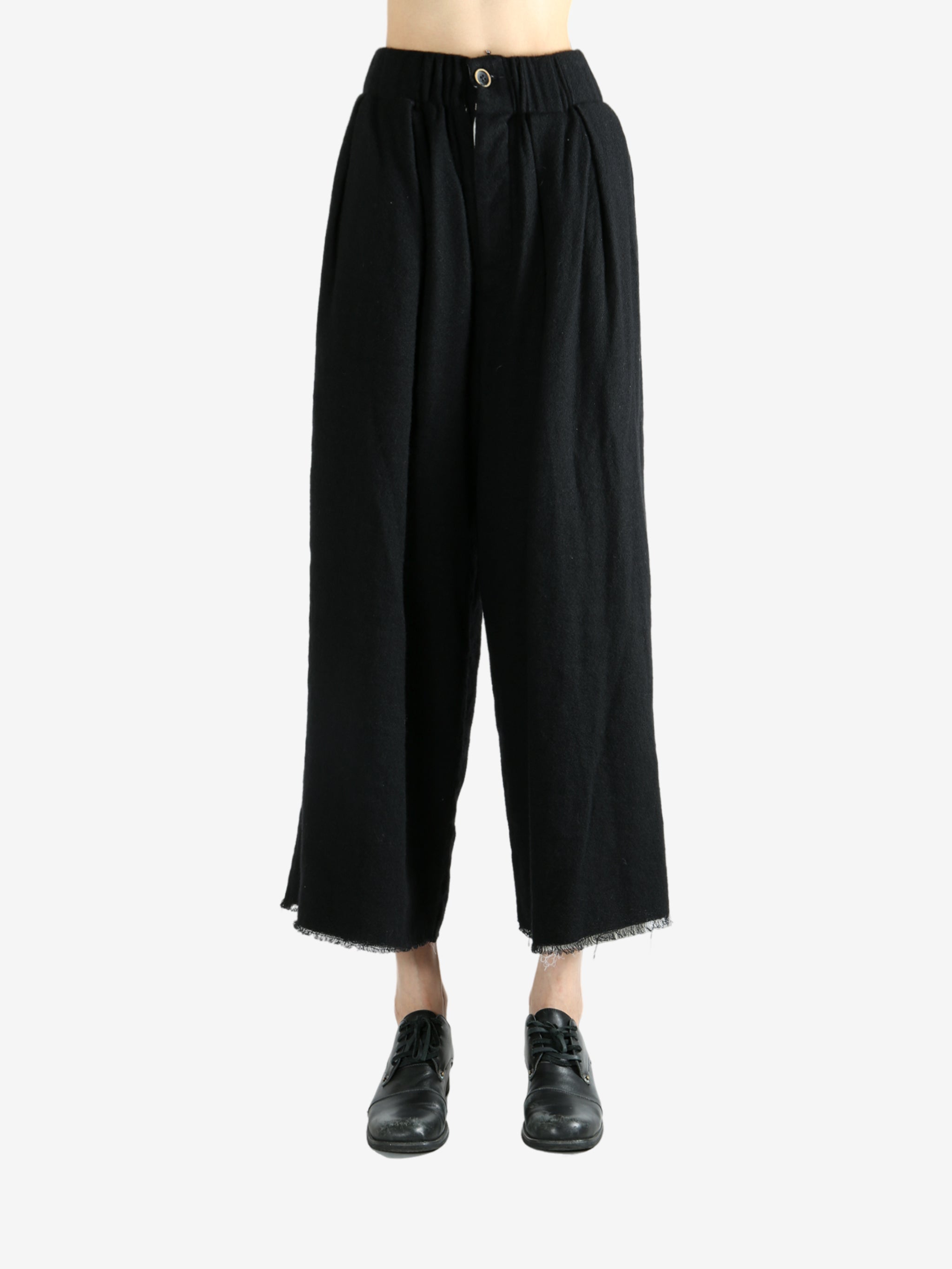 Black pants worn by a person, showing the pants fit