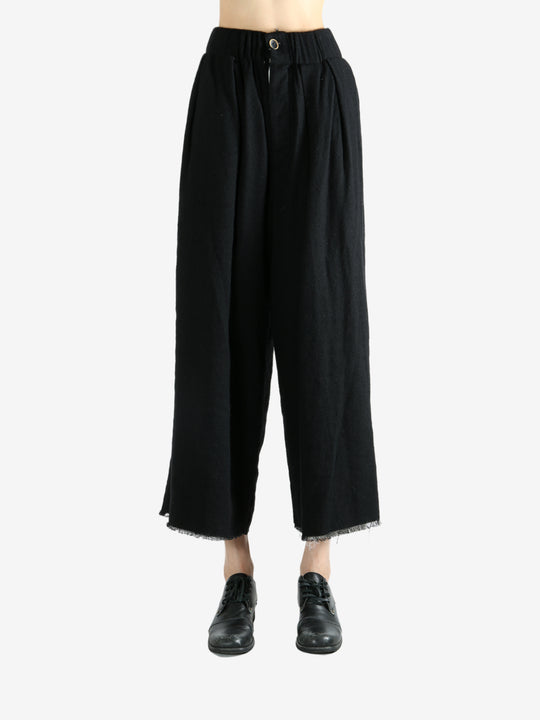 Black pants worn by a person, showing the pants fit