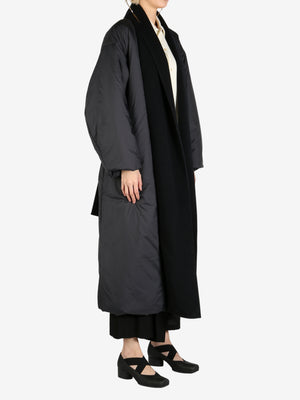Black coat worn by a person, showing the coat fit