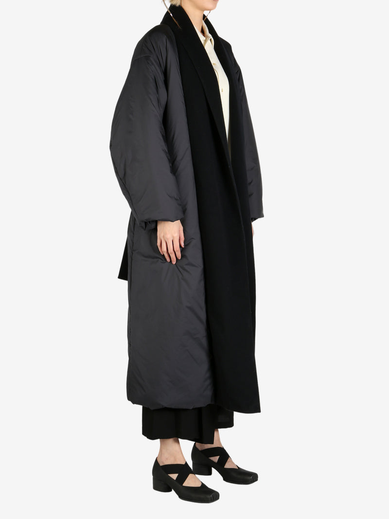 Black coat worn by a person, showing the coat fit