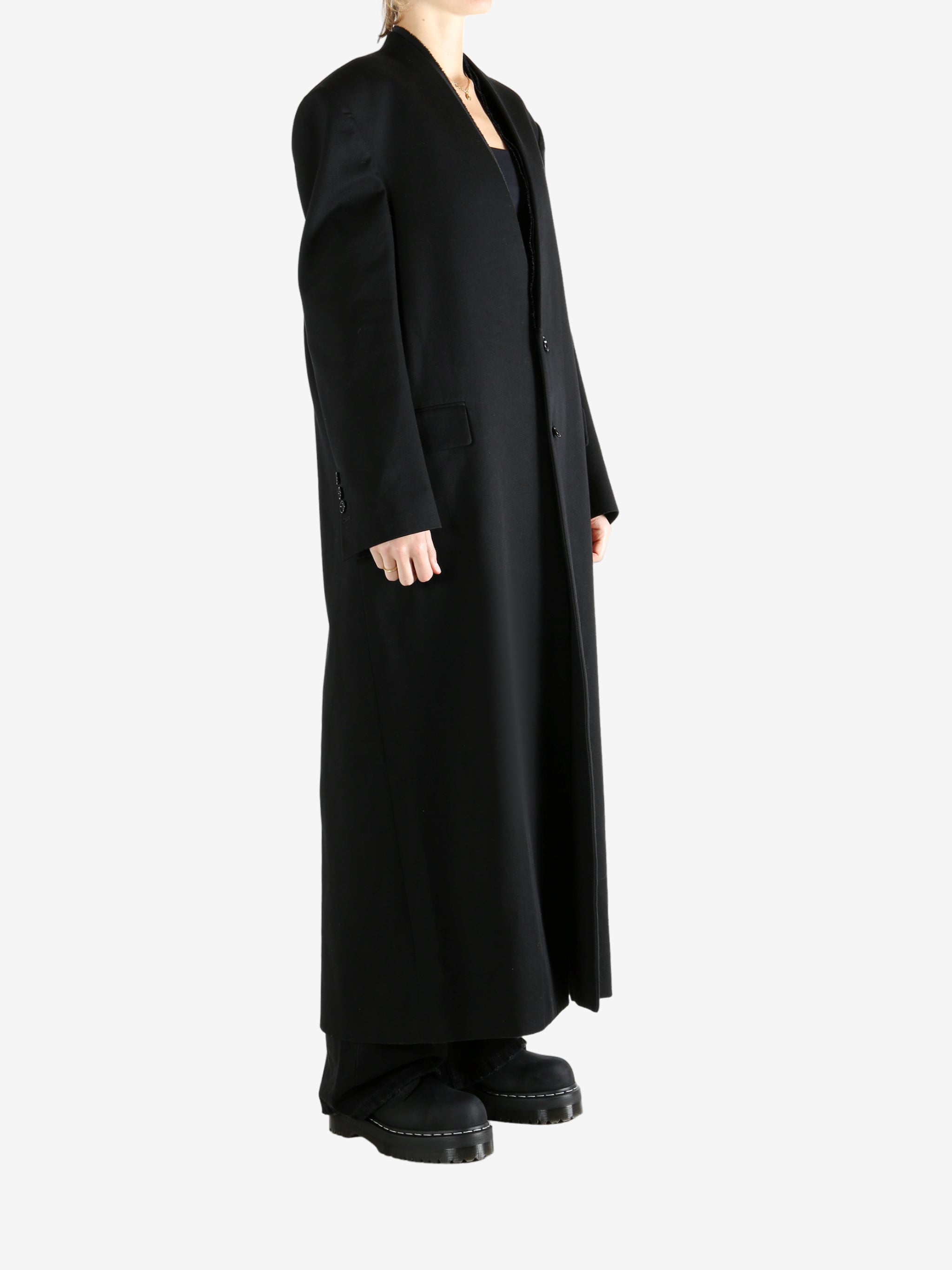 Black coats worn by a person, showing the coats fit