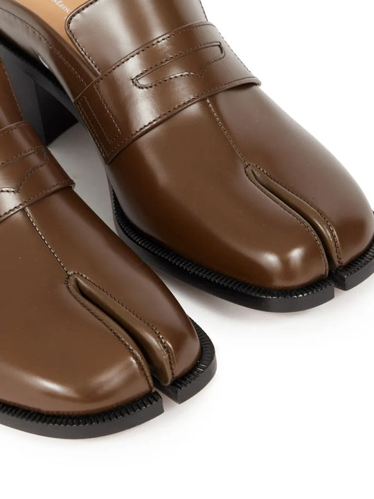 Close up of the brown mules, showing texture of the leather fabric