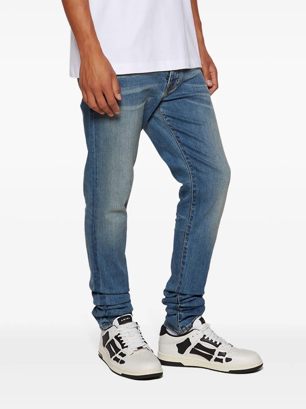 White sneaker worn by a person, showing the sneaker's fit