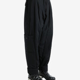 Black pants worn by a person, showing the pants' fit