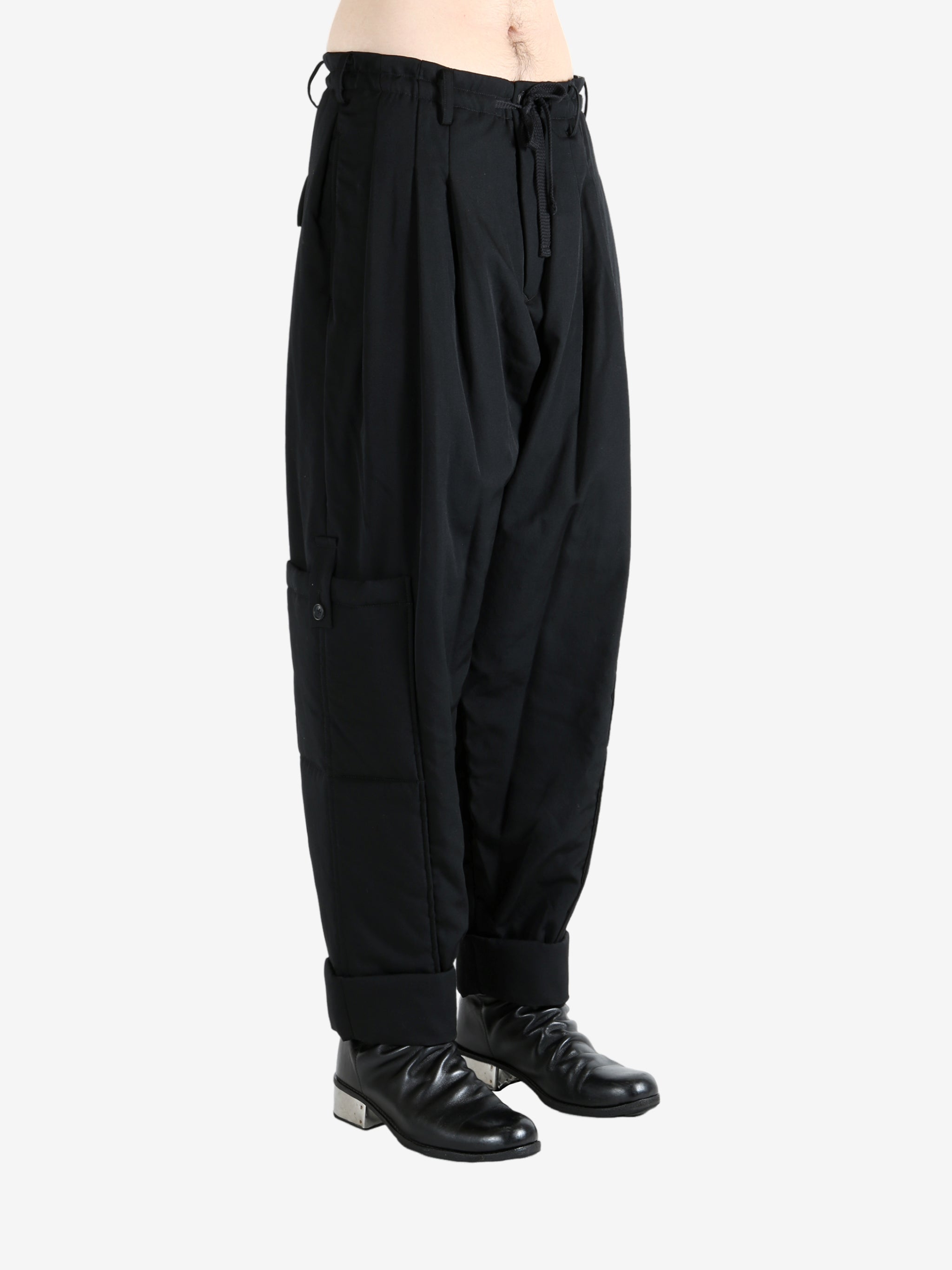 Black pants worn by a person, showing the pants' fit