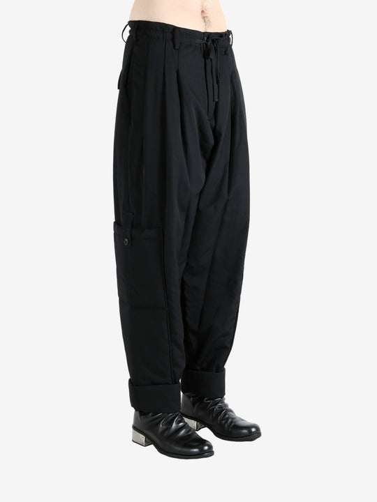 Black pants worn by a person, showing the pants' fit