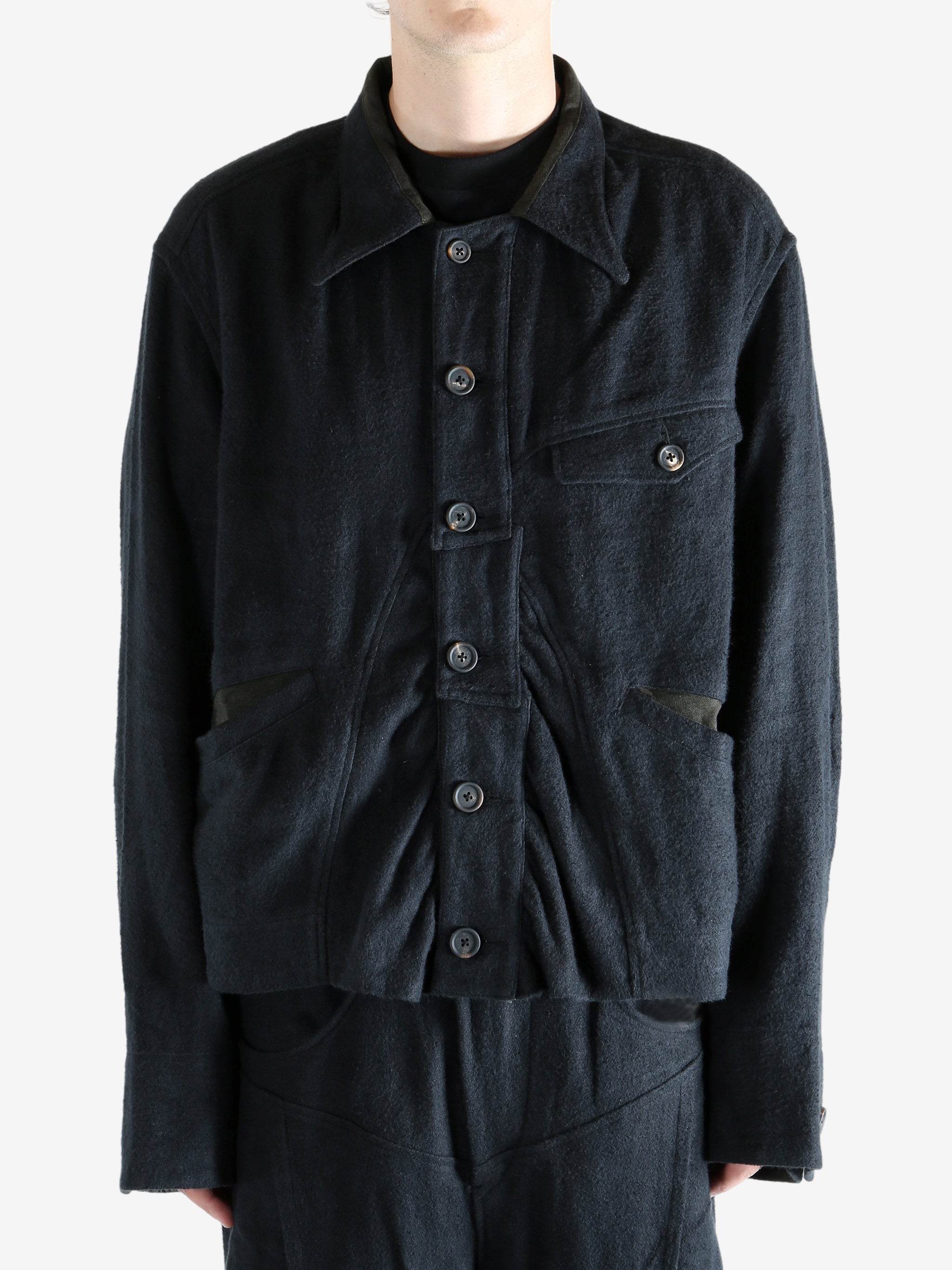 Black jacket worn a person, showing the jacket's fit