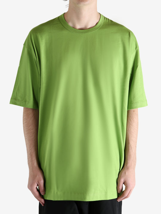 Green t-shirt worn by a person, showing the shirt's fit