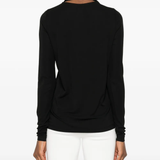 Black tops worn by a person, showing the tops' fit