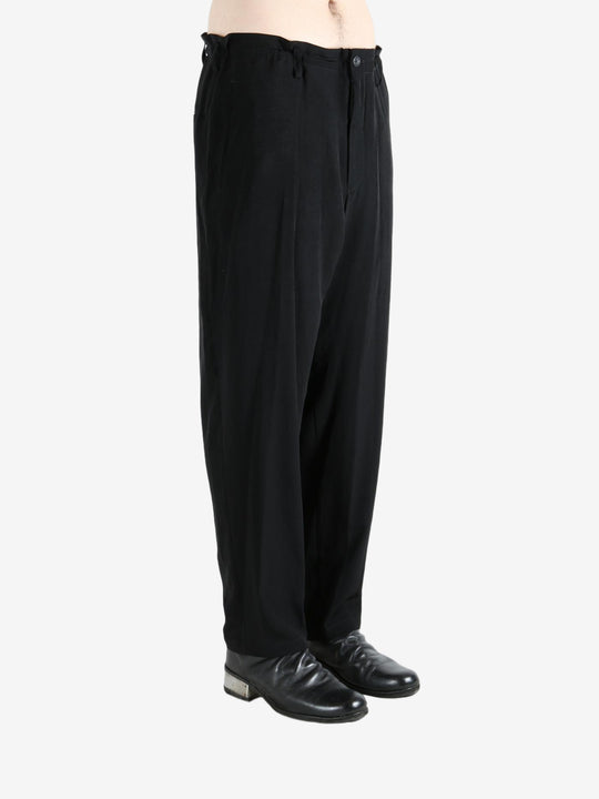 Black pants worn by a person, showing the pants's fit