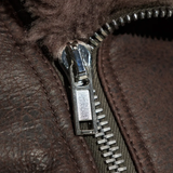 Close up of the brown jacket, showing texture of the leather and wool fabric