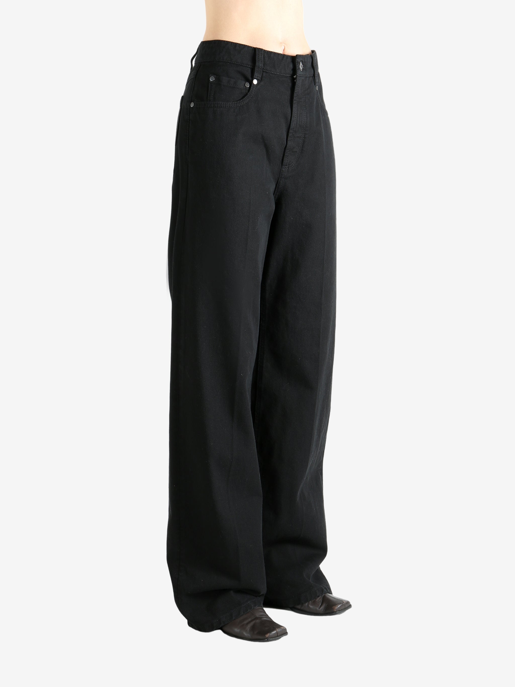 Black pants worn by a person, showing the pant's fit