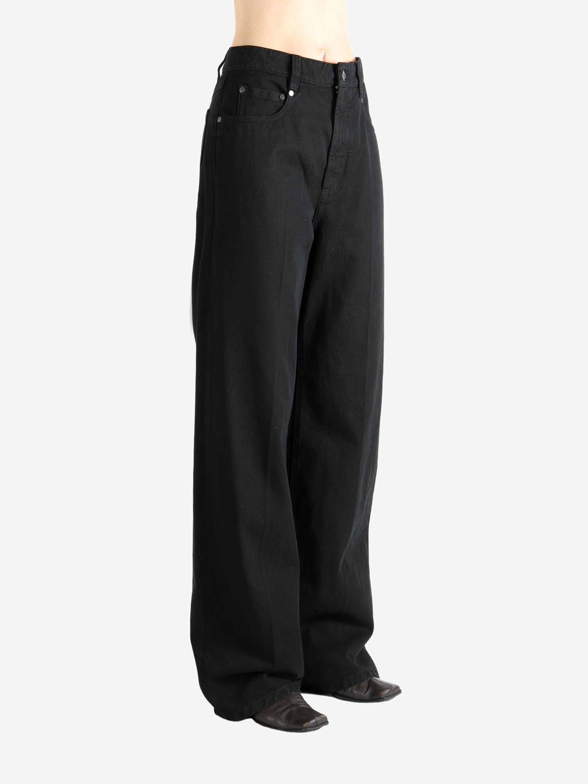 Black pants worn by a person, showing the pant's fit