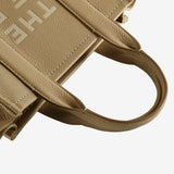 Close up of tan bag, showing texture of the leather fabric
