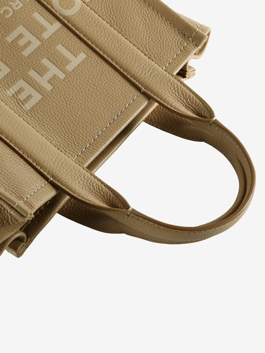 Close up of tan bag, showing texture of the leather fabric