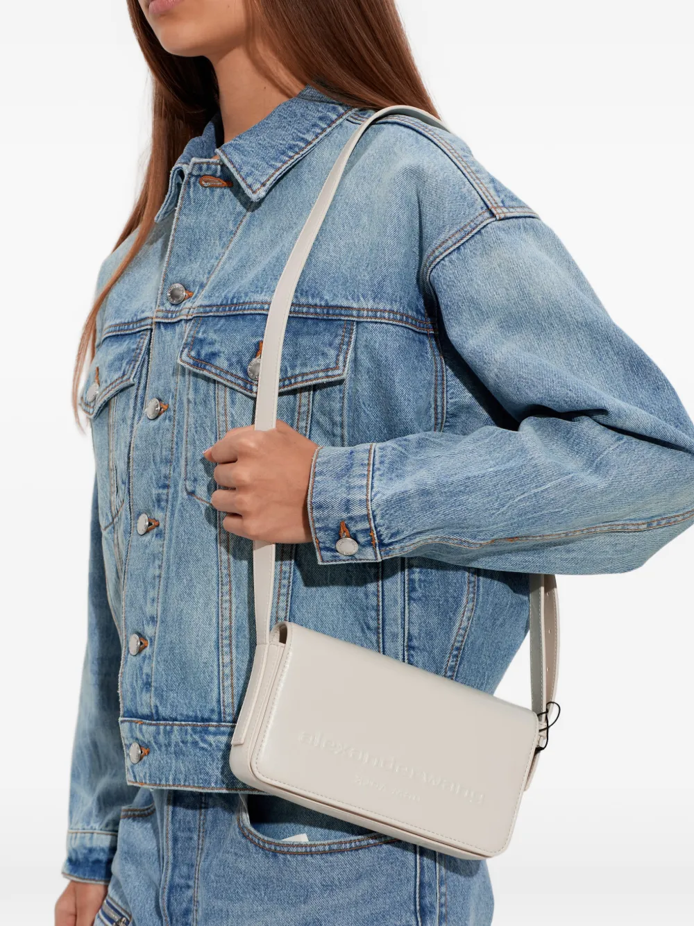 White handbag worn by a person, showing the handbag fit