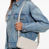 White handbag worn by a person, showing the handbag fit