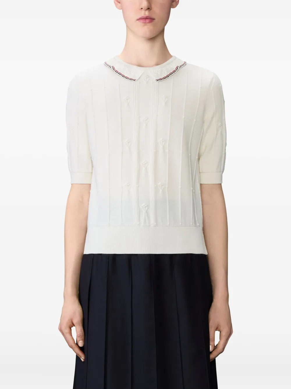 White knitwear worn by a person, showing the knitwear's fit